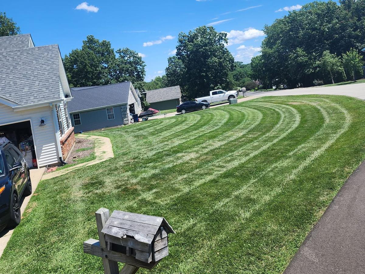 Freshly mowed lawn with clean stripes in front of a home