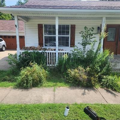 Overgrown front bed by the porch before