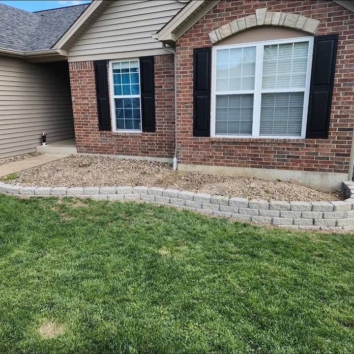 Clean lawn and block-edged bed in front of the brick home
