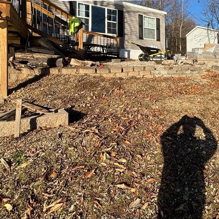 Bare, sloped backyard dirt before the retaining wall